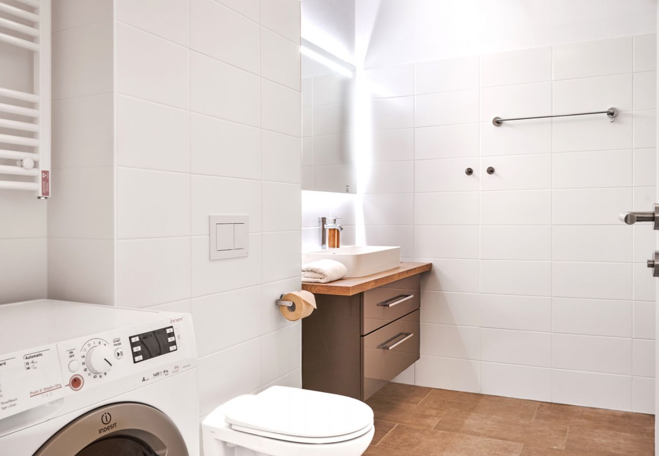 Badezimmer mit Waschmaschine in der Ferienwohnung Adler Lodge D5 in Tauplitz